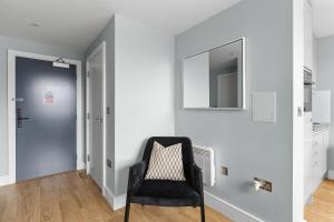 チェルムスフォードにあるLuxurious One Bedroom Apartment in Bond Streetの黒い椅子と鏡付きの部屋