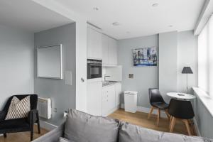 Luxurious One Bedroom Apartment in Bond Street في تشيلمسفورد: غرفة معيشة مع أريكة وطاولة وكراسي