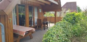 a patio with a table and chairs on a house at Ferienhaus Sturmtaucher in Otterndorf