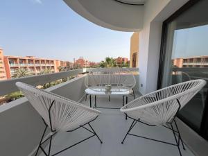 un balcón con 2 sillas y una mesa en el balcón en Appartement dans triangle d’or en Marrakech
