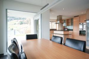 cocina con mesa de madera y sillas negras en Haus Gmür Amden Obergeschoss en Amden