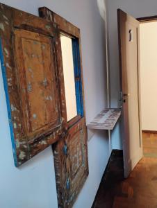 una antigua puerta de madera en una habitación con un banco en Pousada Seu Souza en Belo Horizonte