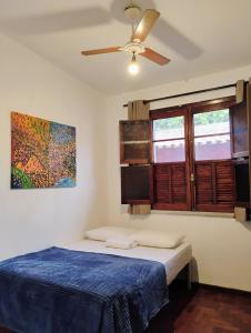 1 dormitorio con 1 cama y ventilador de techo en Pousada Seu Souza en Belo Horizonte