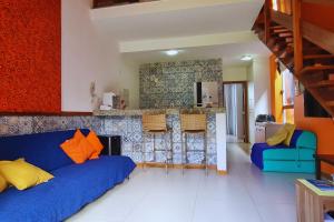 a living room with a blue couch and a kitchen at Solaris 6 - duplex 2 quartos 10 mn a pé da praia in Imbassai