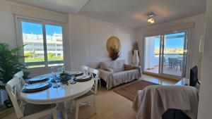 ein Esszimmer mit Tisch und Stühlen und ein Zimmer mit Aussicht in der Unterkunft Tranquil sunny apartment las Terrazas de la Torre Golf Resort Spain in Murcia