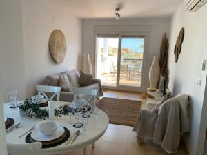 ein Wohnzimmer mit Tisch und Couch in der Unterkunft Tranquil sunny apartment las Terrazas de la Torre Golf Resort Spain in Murcia