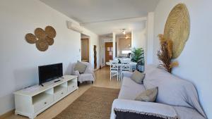 ein Wohnzimmer mit Sofa und Fernseher in der Unterkunft Tranquil sunny apartment las Terrazas de la Torre Golf Resort Spain in Murcia