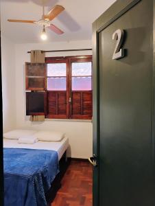 Puerta a una habitación con cama y ventana en Pousada Seu Souza en Belo Horizonte