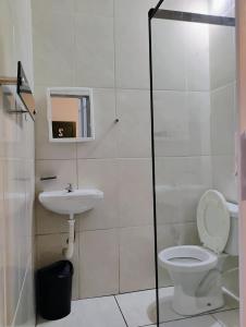 La salle de bains est pourvue de toilettes et d'un lavabo. dans l'établissement Pousada Seu Souza, à Belo Horizonte