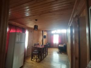 cocina con mesa y nevera en una habitación en Cabañas EcoSur - Chile, en Curacautín