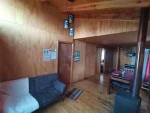 Una sala de estar con un sofá y un piano. en Cabañas EcoSur - Chile, en Curacautín