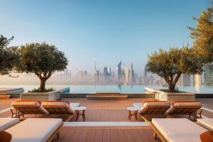 a rooftop patio with chairs and a view of the city at One&Only One Za'abeel in Dubai