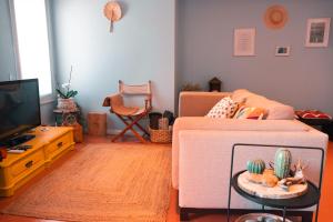 a living room with a couch and a tv at CABEDELO BEACH FLAT in Viana do Castelo