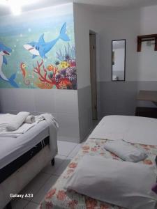 2 camas en una habitación con un cuadro en la pared en Pousada Porto Marola, en Porto de Galinhas