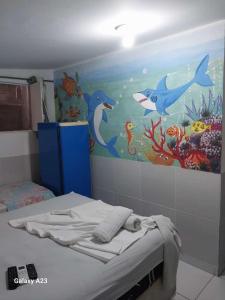 1 dormitorio con una pintura de delfines y un acuario en Pousada Porto Marola, en Porto de Galinhas