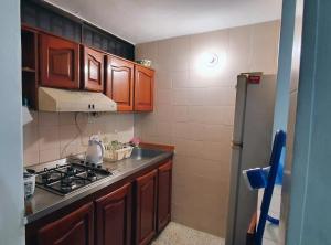 a kitchen with wooden cabinets and a stove top oven at Los Alcatraces in Santa Marta
