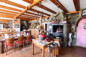 um restaurante com mesas e cadeiras de madeira e uma parede de pedra em Casa Rural Restaurant Borda Patxeta em Canillo