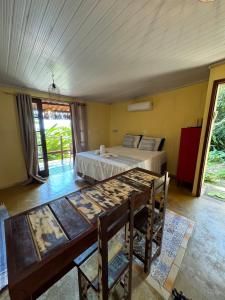 um quarto com uma cama, uma mesa e cadeiras em Chalé Maria Bonita - Ilha Grande, RJ em Angra dos Reis