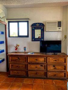 a large wooden dresser with a tv on top of it at Hermosa vista de la bahía de Zihuatanejo in Zihuatanejo