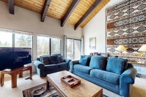 a living room with blue couches and a tv at Katherine Court Townhouse in Stateline