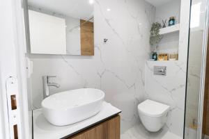biała łazienka z umywalką i toaletą w obiekcie Your Destination w Lixoúrion