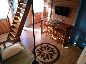 uma sala de estar com uma escada e uma televisão em Chalé Bienen Garten em Pomerode