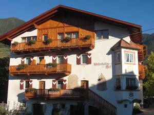 a large white building with a balcony at Garni Unterhaslerhof in Merano