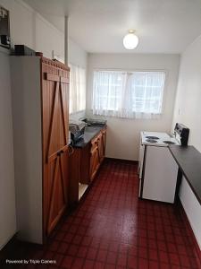 a small kitchen with a red tile floor at The Cave Motel in Levin