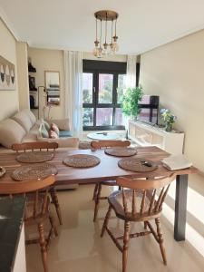 uma sala de estar com uma mesa de madeira e cadeiras em Ribeles Luxury Flat em Arenas de Cabrales