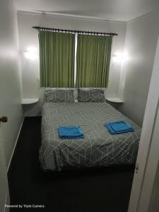 a bedroom with a bed with blue towels on it at The Cave Motel in Levin