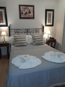 Una cama con dos toallas encima. en Hotel Azul Junin en Junín