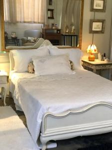 Una cama blanca con un osito de peluche acostado en ella en Body & Mind Beautiful - Suites Elegantes e Charmosas, en Franca