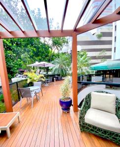 una gran terraza de madera con sillas y mesa. en 205 Flat/Studio Elegance Jardins- Cozinha Completa, en São Paulo