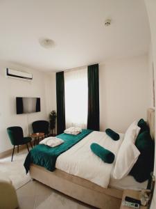 - une chambre dotée d'un grand lit avec des draps verts et blancs dans l'établissement Wing Nina2, à Jagodina