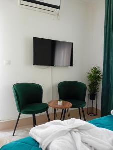 a bedroom with two chairs and a tv on the wall at Wing Nina2 in Jagodina