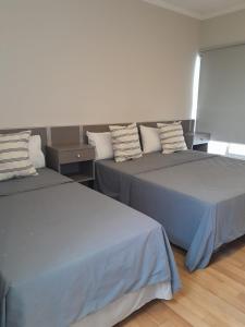 2 Betten nebeneinander in einem Zimmer in der Unterkunft Hotel Azul Junin in Junín