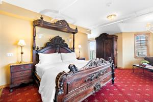 a bedroom with a large bed with a wooden frame at Majestic Hotel in Ocean Grove