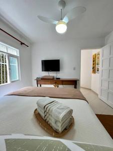 a white bedroom with a bed with a fan at Cantinho Ítalo-Germânico Hospedagem - Suíte Girassol - Centro, Marechal Floriano-ES in Marechal Floriano +18 photos