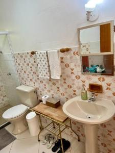 y baño con aseo y lavamanos. en Suíte Girassol Cama & Café - Centro, Marechal Floriano-ES, en Marechal Floriano