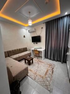 ein Wohnzimmer mit einem Sofa und einem Tisch in der Unterkunft Hotel Eloued فندق الوادي in Tiksebt