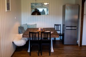 a dining room table with two chairs and a refrigerator at Fjellhagen in Bjørkheim