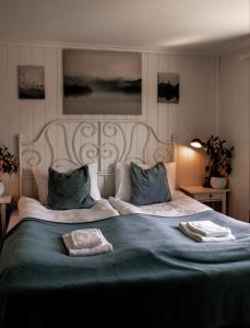a bedroom with a large bed with two towels on it at Fjellhagen in Bjørkheim