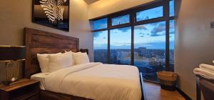Un dormitorio con una cama y una ventana grande en Serenity - Breathtaking Views, en Nairobi