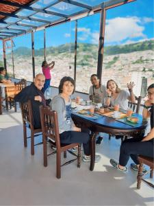 un grupo de personas sentadas alrededor de una mesa en Hostal La Terraza en Quito
