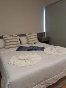 2 Handtücher auf einem weißen Bett in einem Zimmer in der Unterkunft Hotel Azul Junin in Junín