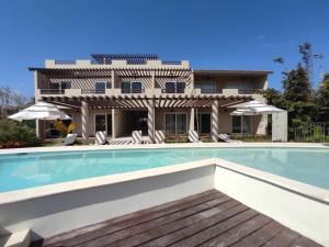 a swimming pool in front of a house at Brand new Studios and Apartments in Puerto Aventuras