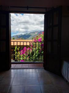 an open door to a balcony with pink flowers at Lo de Mora in Cafayate