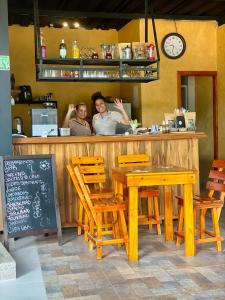 2 personnes debout au comptoir d'un restaurant dans l'établissement Coffee House Minca, à Minca