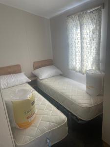a room with two beds and a window at Caravan by the beach in Borth
