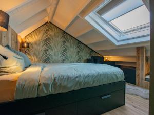 1 dormitorio con 1 cama grande y tragaluz en Spoelde wiel, en Callantsoog